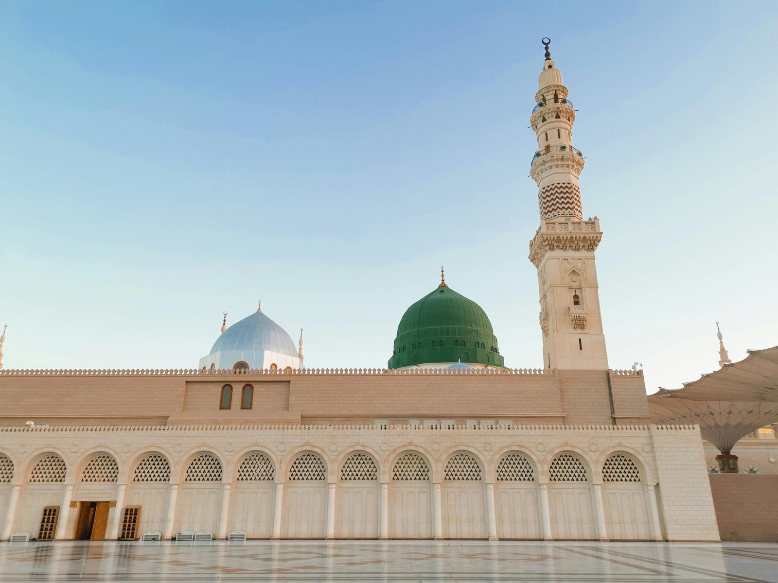 The mosque is surrounded by green and white domes